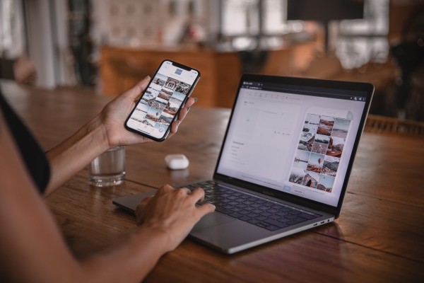 Woman Comparing Webpage on Phone vs Laptop